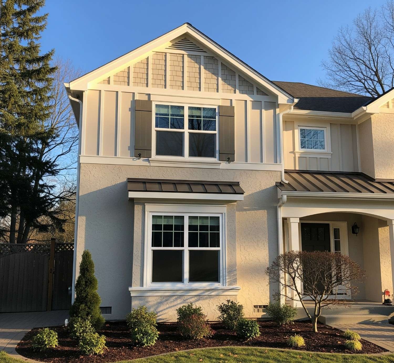 A house exterior showcasing the completed board and batten siding installed over stucco, highlighting its aesthetic appeal and clean finish.